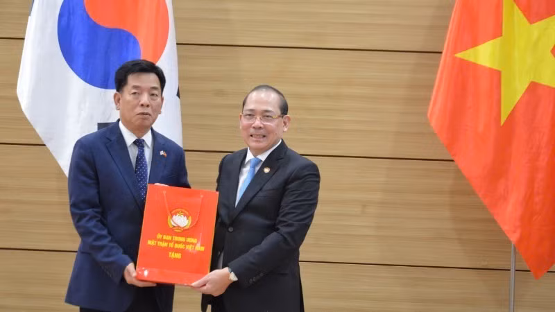 Vice President of the Viet Nam Fatherland Front Central Committee Hoang Cong Thuy presents a commemorative gift to Ambassador Vu Ho.