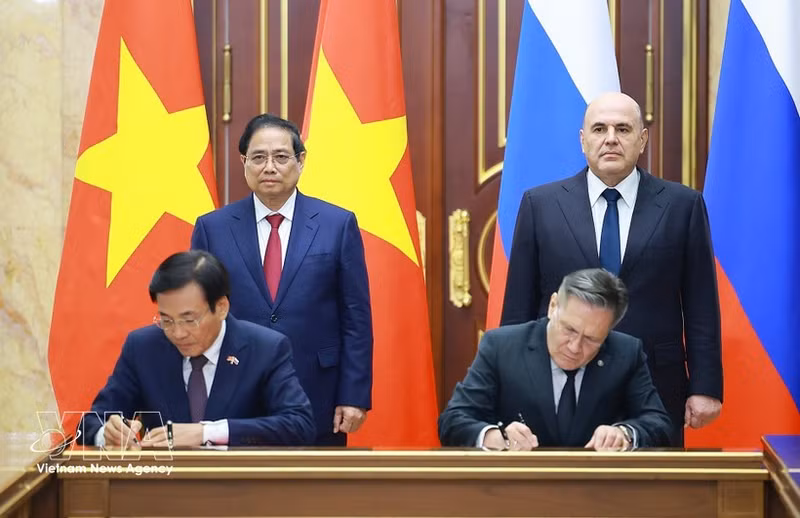 Vietnamese PM Pham Minh Chinh (standing, left) and his Russian counterpart Mikhail Mishustin (standing, right) witness the signing of the agreement between the two governments on cooperation in building a nuclear power plant on the territory of Viet Nam. (Photo: VNA)