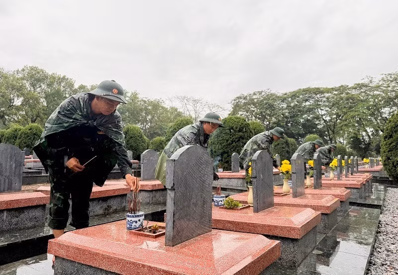 Soldiers of the Dien Bien Provincial Military Command offer incense at the graves of fallen soldiers at Doc Lap Martyrs' Cemetery.