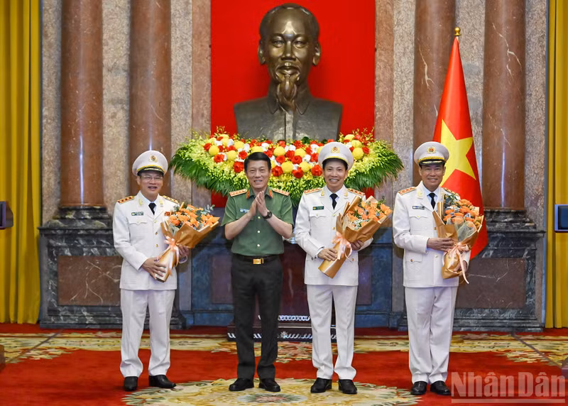 Minister of Public Security Luong Tam Quang offers flowers in celebration.