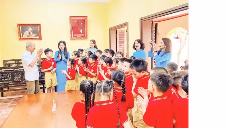 Cong Ngoc Dung tells stories about President Ho Chi Minh to teachers and students of Phu Thuong Primary School during a local history lesson at the relic site of Nguyen Thi An's house.