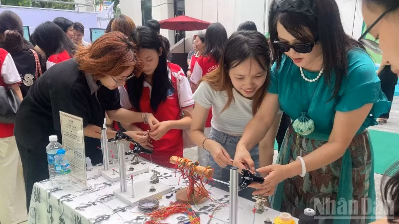 Visitors take part in a five-coloured bracelet-weaving activity.
