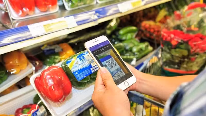 A consumer scan QR codes to verify product information and origins at a supermarket in Ha Noi. (Photo: Ha Thu)