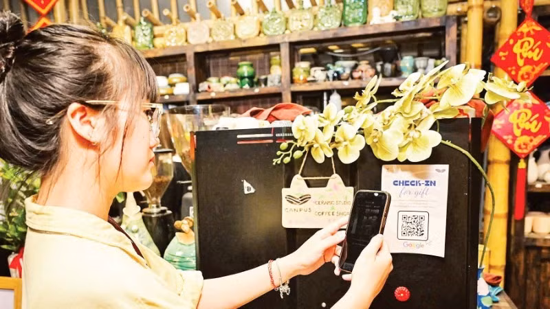 A customer scan QR codes to make cashless payments at a shop on Van Mieu Street, Ha Noi. (Photo: BAO LONG)