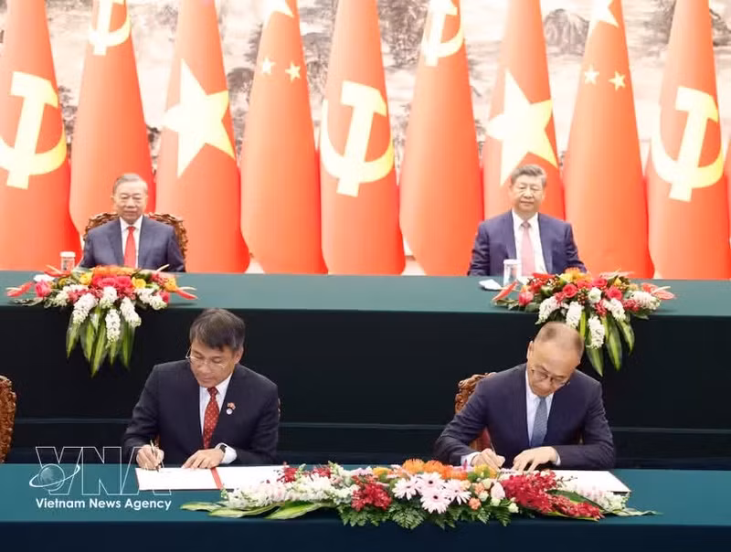General Secretary of the Communist Party of Viet Nam Central Committee and President of Viet Nam To Lam (left, back) and his Chinese counterpart Xi Jinping witness the signing of cooperation agreements between the two countries on April 15, 2026. (Photo: VNA)