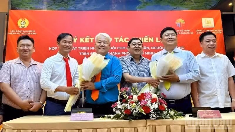 Representatives of the municipal Labour Federation sign a memorandum of understanding with Go Holdings Group Joint Stock Company on cooperation in developing housing for workers in the city. (Photo: Vuong Le)