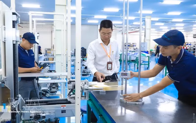 Bui Anh Long, CEO of TAZMO Co., Ltd., inspects a wafer transfer robot used in the semiconductor industry. (Photo: VNA)