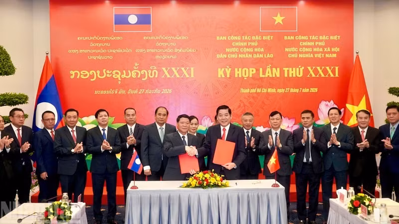 Representatives of Viet Nam's and Laos' Special Working Committees sign the meeting minutes.