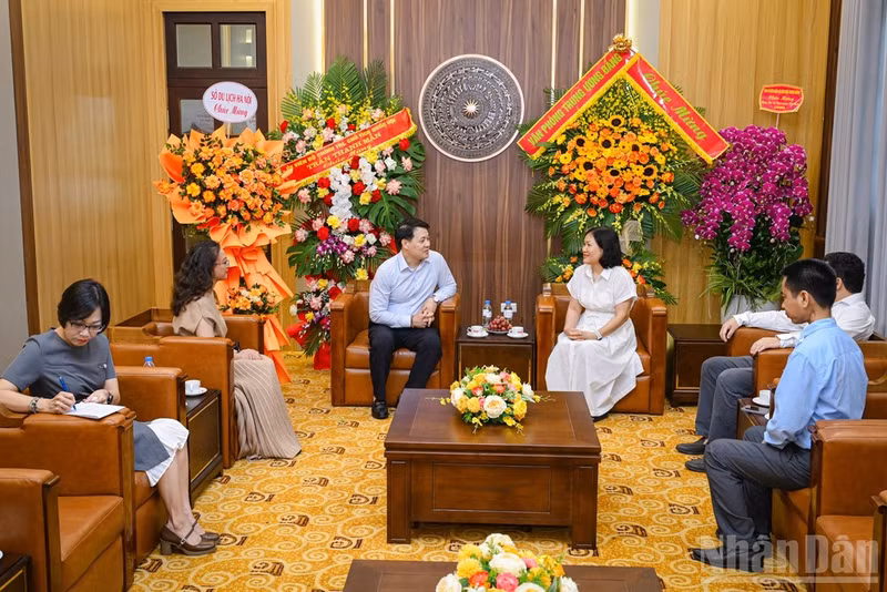 Kieu Thanh Huong, Deputy Head of the Resident Correspondents Management Department of Nhan Dan Newspaper, and Nguyen Tran Quang, Deputy Director of the Ha Noi Department of Tourism, join a delegation visiting and congratulating the newspaper.