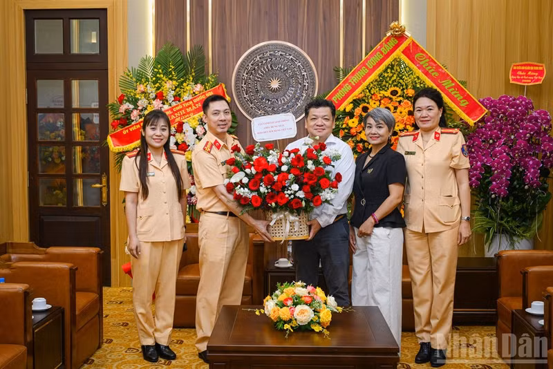 Phan Bang Son, Deputy Chief of Office of Nhan Dan Newspaper, and Colonel Pham Viet Cong, Deputy Director of the Traffic Police Department under the Ministry of Public Security, pose for a photograph during the visit.