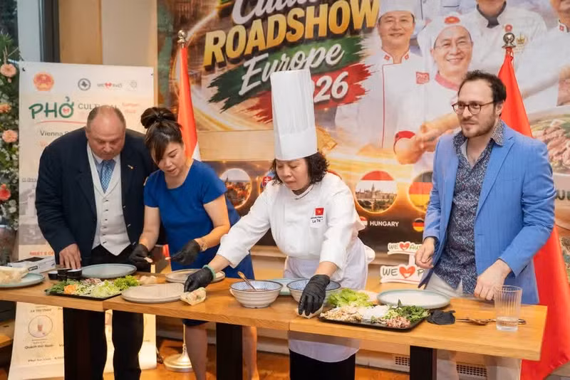 Visitors participate in a live demonstration of pho roll preparation at the event. (Photo: NDO)
