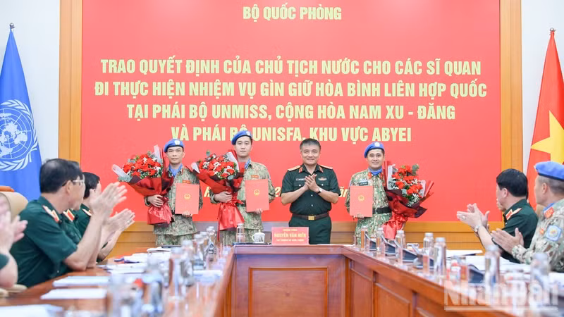 Senior Lieutenant General Nguyen Van Hien presents the President’s decisions to three officers assigned to UN peacekeeping missions. (Photo: NDO)
