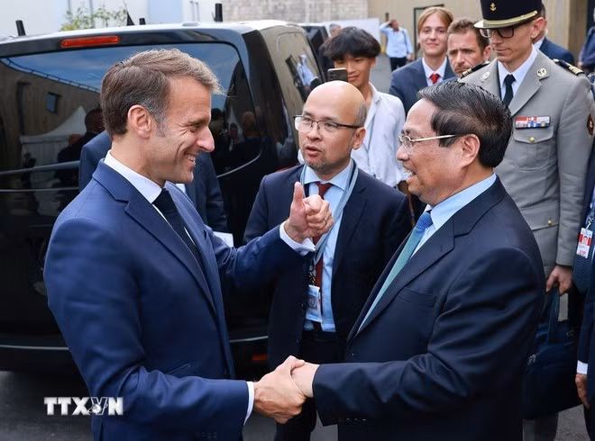 Prime Minister Pham Minh Chinh (R) is welcomed by French President Emmanuel Macron (Photo: VNA)