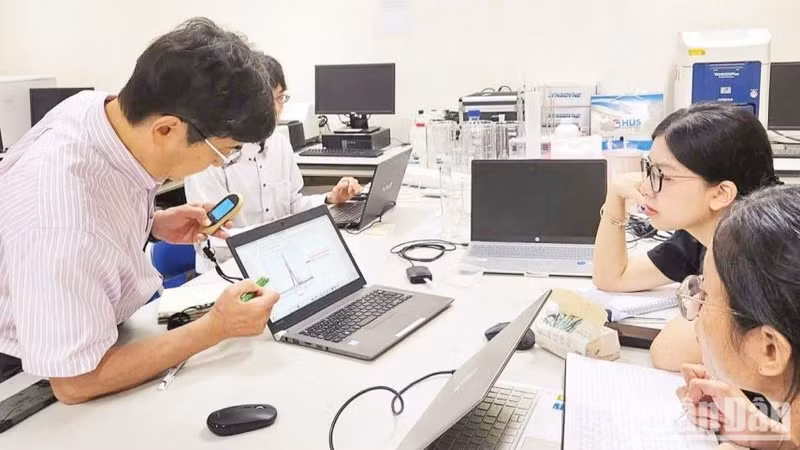 Japanese experts and Vietnamese researchers discuss at the national key laboratory for advanced materials for green development, Viet Nam National University, Ha Noi. (Photo: HA LINH)