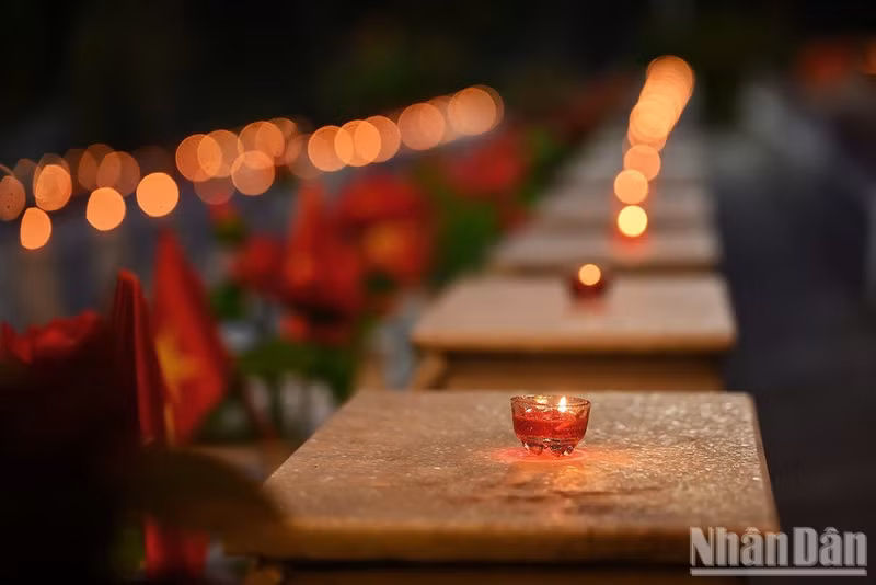 Lighting candles to pay tribute to martyrs at Vi Xuyen National Martyrs Cemetery, Tuyen Quang, on the evening of July 14, 2026. (Photo: LINH PHAN)