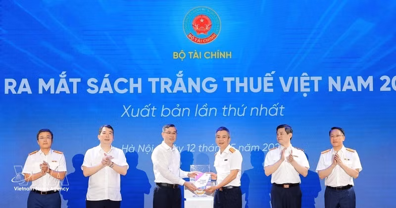 Minister of Finance Ngo Van Tuan (third from left) presents the White Book on Viet Nam Taxation 2026 to Director the Tax Department Mai Xuan Thanh at the launch in Ha Noi on May 12. (Photo: VNA)