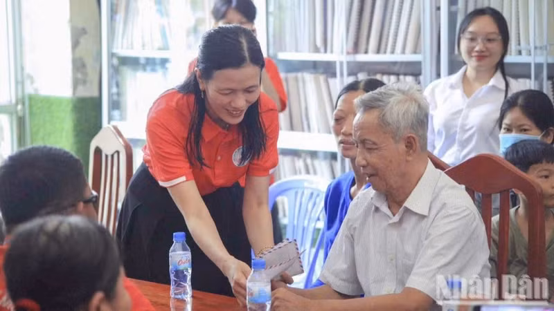 Nguyen Thi Minh Tam presents gifts to people facing difficulties. (Photo: LY OANH)