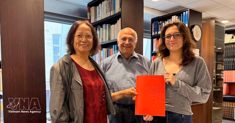 Cultural researcher Tran Thu Dung (left), Yonnel Ghernaouti, a member of the Executive Board of the French Institute for Masonic Studies, and Emma Lallemand, a librarian at the Grand Orient de France, pose with archival documents relating to Nguyen Ai Quoc. (Photo: VNA)