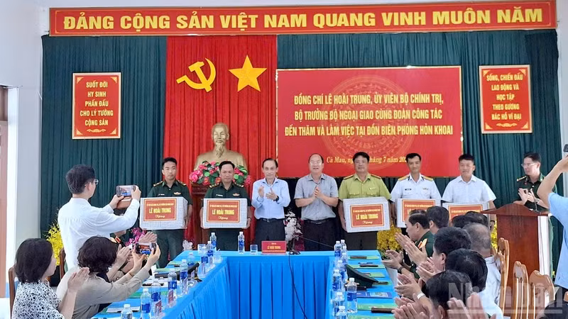 Minister Le Hoai Trung (third from the left) and Nguyen Ho Hai, Secretary of the Ca Mau Provincial Party Committee (fourth from the left), present gifts to outstanding officers, soldiers, workers, and employees who steadfastly serve on Hon Khoai Island. (Photo: nhandan.vn)