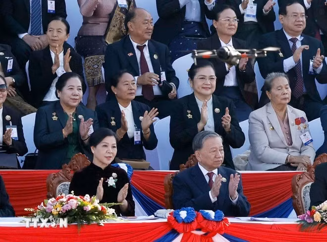 Party General Secretary To Lam and his spouse at the celebration of Laos' 50th National Day anniversary (Photo: VNA)