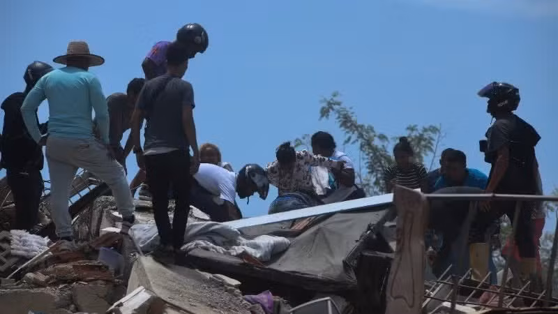 Rescue workers and residents search for victims beneath the rubble following an earthquake in La Guaira State, Venezuela. (Illustrative photo: Xinhua/VNA)