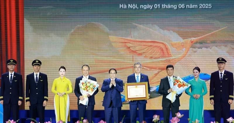Prime Minister Pham Minh Chinh awards a certificate of merit to Viet Nam Airlines. (Photo: VNA)