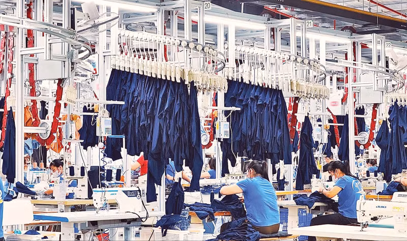 An automated overhead conveyor system in the garment factories of TNG Investment and Trading Joint Stock Company delivers products to each worker's station. (Photo: THE BINH)