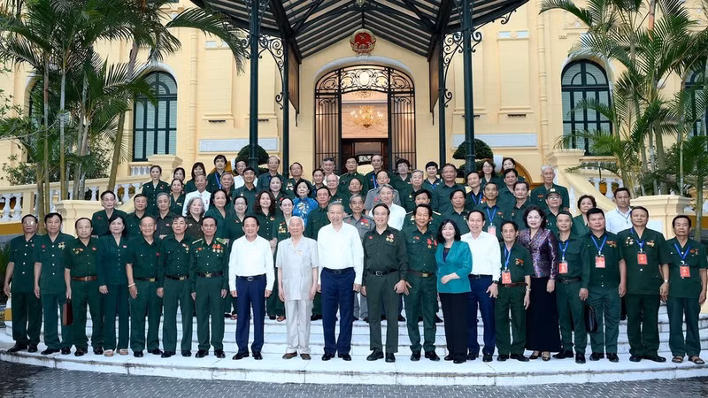 Party General Secretary and President To Lam (10th from left, first row) poses for a photo with former youth volunteers. (Photo: NDO)