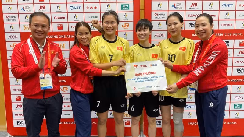 Head of the Viet Nam Sports Delegation Nguyen Hong Minh presents a bonus to the Vietnamese women's sepak takraw team following the direction of Minister of Culture, Sports and Tourism Lam Thi Phuong Thanh. (Photo: BUI LUONG)