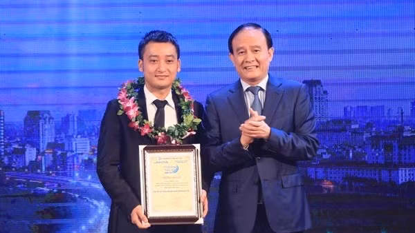 Vice Chairman of Hanoi People's Council Standing Committee Nguyen Ngoc Tuan presents an award to author Dinh Quoc Thai, the overall winner of the 2016 competition.