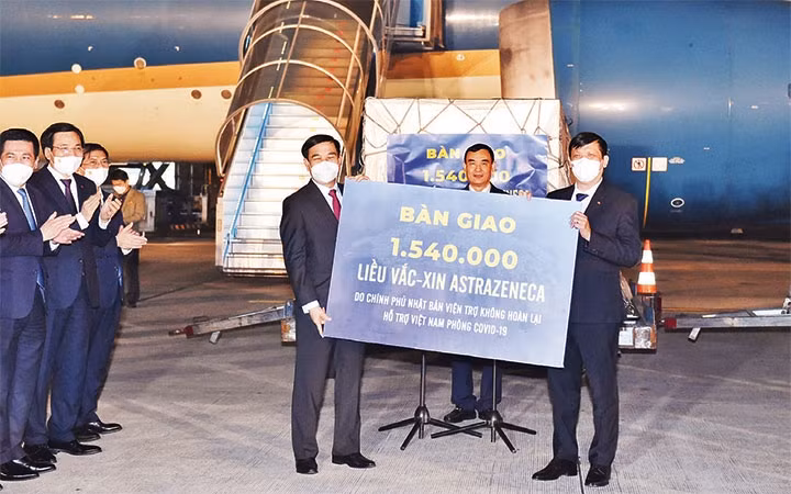 General Phan Van Giang, Politburo member and Minister of National Defence hands over 1.54 million doses of AstraZeneca vaccine to Health Minister Nguyen Thanh Long which is donated by the Japanese Government. (Photo: NHAT BAC)