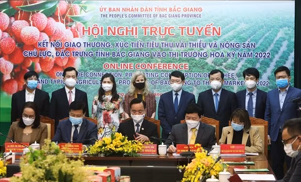 Businesses and agencies sign a memorandum of understanding on lychee export cooperation at the teleconference on March 29. (Photo: VNA)