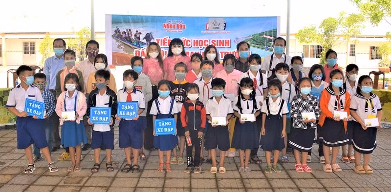 Representatives of Nhan Dan Newspaper in Can Tho and sponsors present scholarships to needy students in Phu Tan district.