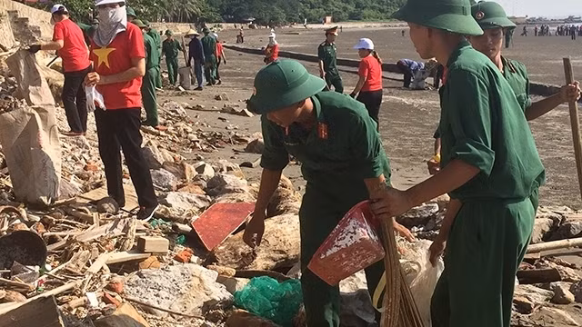 Soldiers join local people in collecting garbage and plastic waste along Do Son beach in Hai Phong city in response to a campaign to make the world cleaner