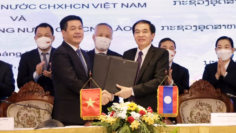 Vietnamese Minister of Industry and Trade Nguyen Hong Dien and his Lao counterpart Khampheng Xaysompheng exchange documents of cooperation. (Photo: VNA)