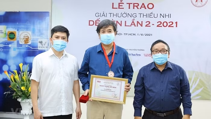 Writer Binh Ca (middle) receives the ‘Cricket Desire’ for his novel ‘Di Tron’ (Seeking shelter). (Photo: VNA)