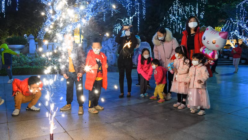 People set off firecrackers by Hoan Kiem Lake.