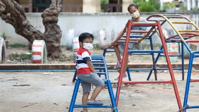Children wear masks while playing outside in Luang Prabang, Laos. (Photo: Xinhua/VNA)