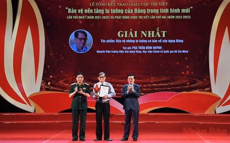 Permanent member of the Party Central Committee’s Secretariat Vo Van Thuong and Minister of Defence Gen. Phan Van Giang present the first prize to Assoc. Prof. Dr. Tran Dinh Huynh.