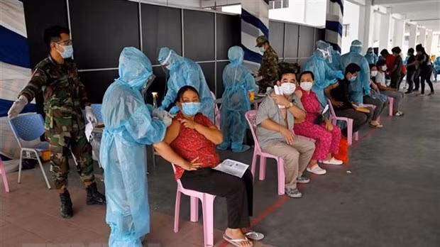 Health workers administer COVID-19 vaccine to people in Phnom Penh, Cambodia. (Photo: AFP/VNA)