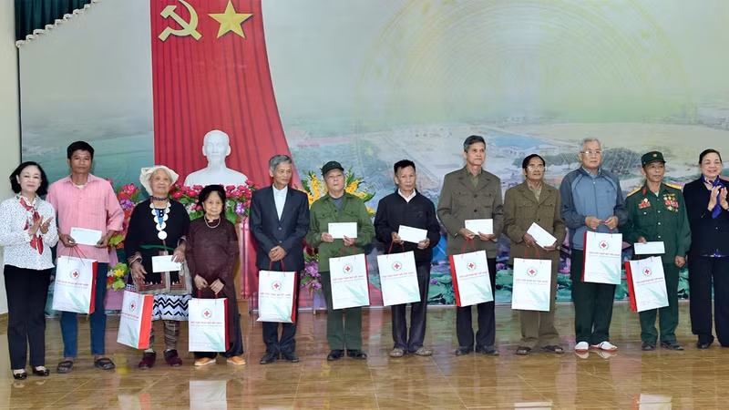 Head of the PCC’s Organisation Commission Truong Thi Mai (leftmost) presents gifts to people with meritorious services to the revolution along with ethnic minorities in difficult circumstances in Xuan Quang Commune, Chiem Hoa District.