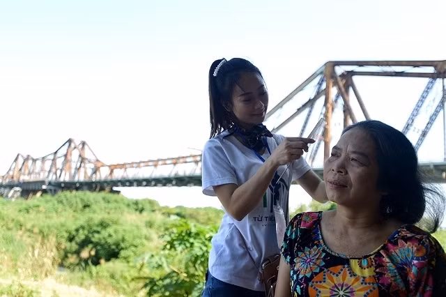 On October 19, the poor boarding hamlet at the foot of Long Bien Bridge became more bustling and busier than usual because the elderly women had the chance to wear Ao Dai (Vietnamese traditional long dress), be made-up beautifully and perform on a stage on the occasion of Vietnam Women’s Day.