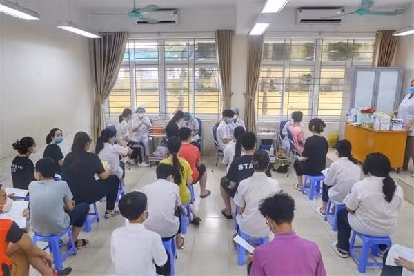 Medical staff give COVID-19 vaccine shots to students of Ha Huy Tap secondary school in Hanoi (Photo: VNA)