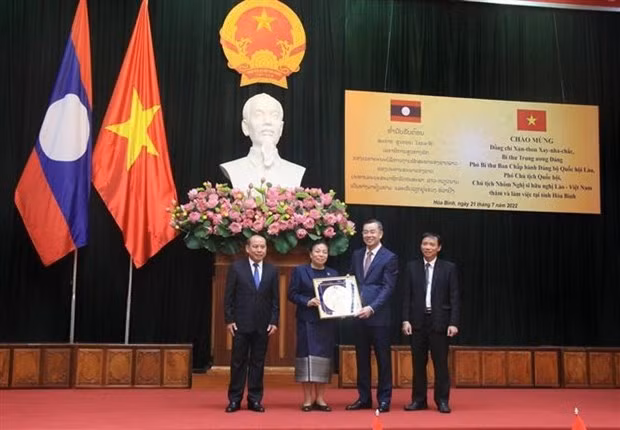 Vice President of the Lao NA Sounthone Xayachack (second, L) present a souvenir to representatives of Hoa Binh province (Photo: VNA)