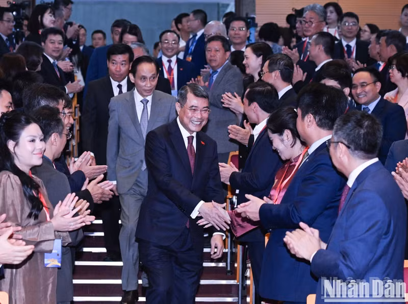 Prime Minister Le Minh Hung shakes hands with delegates attending the plenary session.
