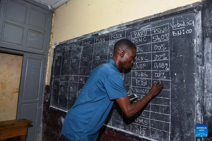 An election official records ballot counts on a blackboard at a polling station in Yaounde, capital of Cameroon, on Oct. 12, 2025. Voting for Cameroon's presidential election ended on Sunday evening, with ballot counting now underway across the country. Polling opened at 8:00 a.m. and closed at 6:00 p.m. local time, with more than eight million registered voters casting their ballots to choose the country's next president. According to Cameroon's Electoral Code, the Constitutional Council must announce the official results within 15 days. (Photo: Xinhua)