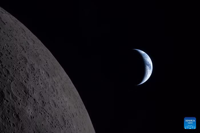 This photo taken on April 6, 2026, shows the Moon (L) and Earth seen from the Orion spacecraft. The crew of the U.S. National Aeronautics and Space Administration (NASA) Artemis II mission began the return phase of their 10-day lunar flight on Tuesday after completing their flyby of the Moon. (NASA/Handout via Xinhua)