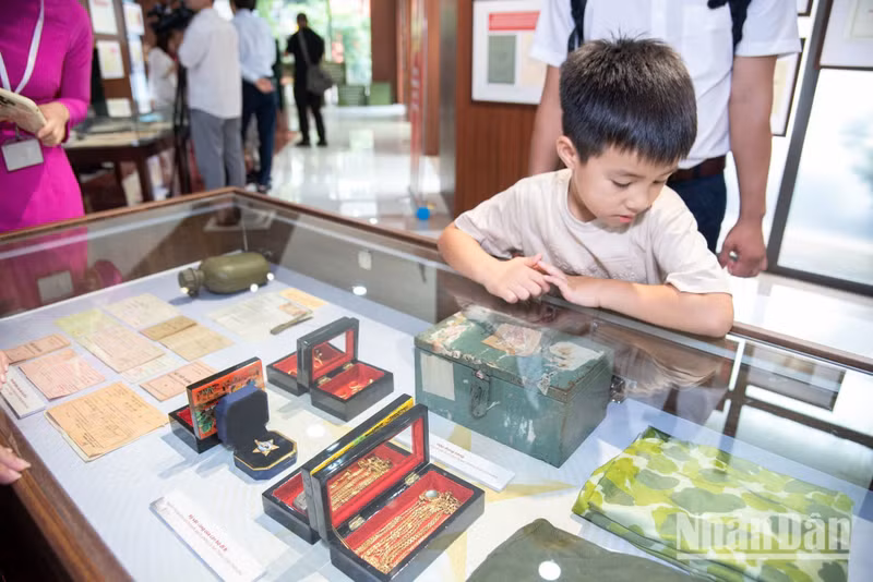The six-year-old boy gazes attentively at the small keepsakes left behind by previous generations. Lessons in patriotism begin with real-life experiences such as these.