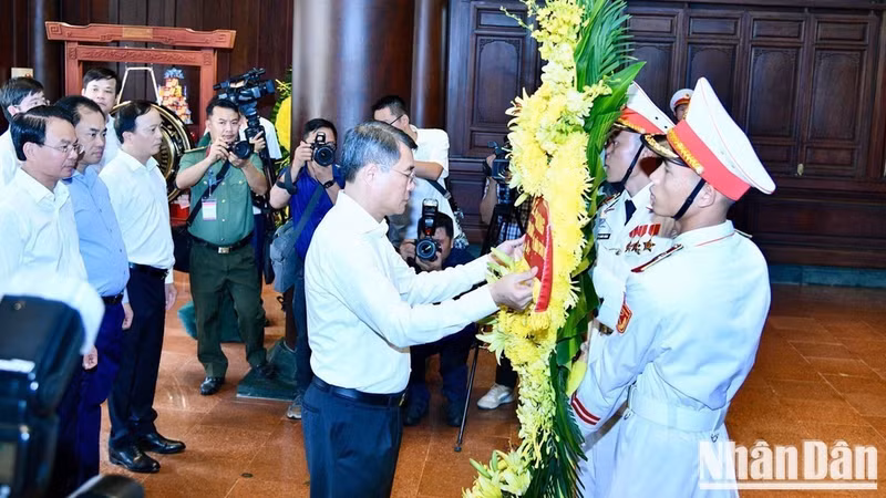 Prime Minister Le Minh Hung adjusts the floral arrangement before offering flowers and incense in commemoration of heroic martyrs who fell on the Dien Bien Phu battlefield. (Photo: THANH GIANG)