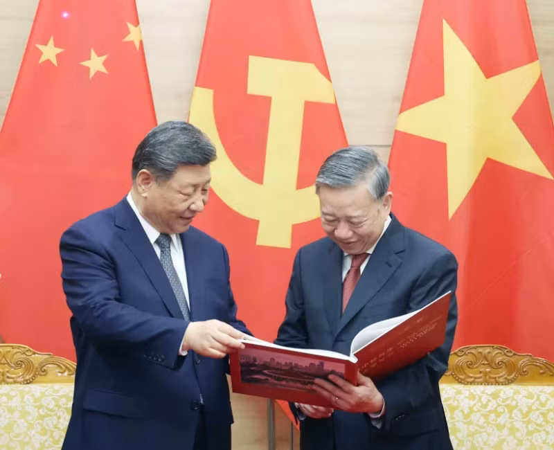 Party General Secretary To Lam (right) presents Party General Secretary and President of China Xi Jinping a photo book by the Vietnam News Agency featuring typical and impressive photos of Xi's five visits to Vietnam since 2011 (Photo: VNA)